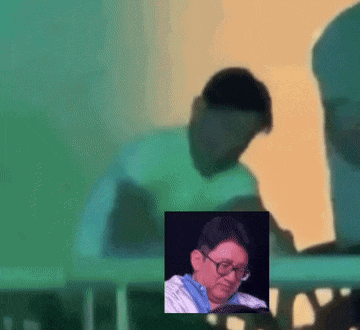 a blurry picture of a man wearing glasses and a blue shirt