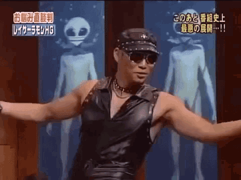 a man in a leather outfit is dancing in front of a picture of an alien