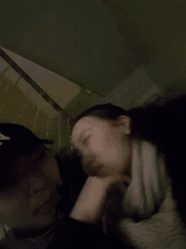 a man kisses a woman on the forehead in a dark room