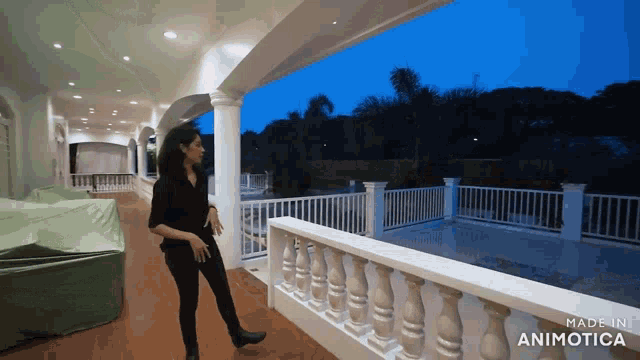 a woman is standing on a balcony with the words made in animatica on the bottom right