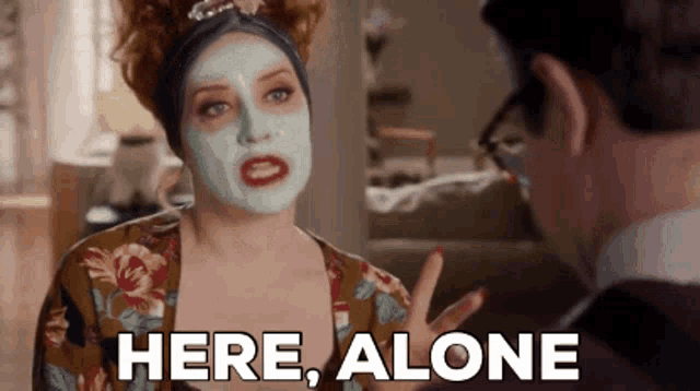 a woman with a face mask is talking to a man and says here , alone .
