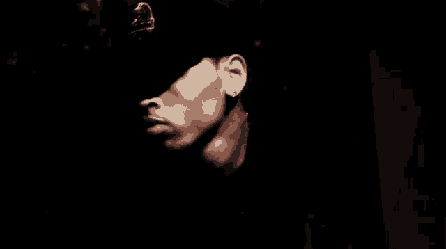 a man wearing a hat and earring with a crown on it