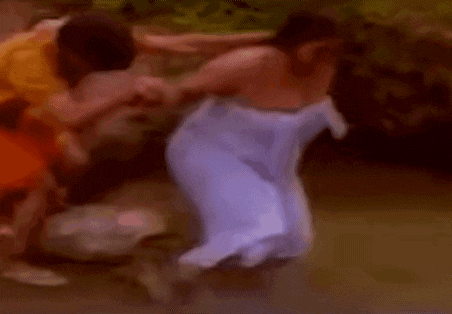 a man is holding a woman wrapped in a towel in a blurry photo .
