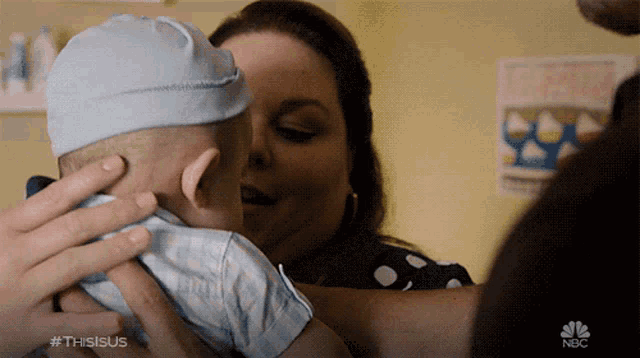 a woman is holding a baby in her arms and the nbc logo is visible in the corner