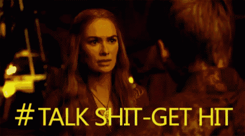 a woman is talking to a man in a dark room and the words `` talk shit-get hit '' are visible .
