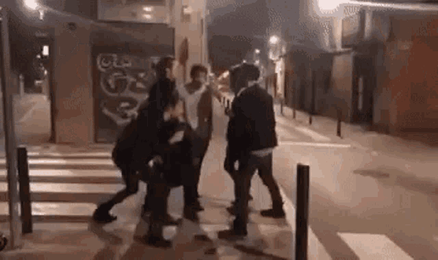 a group of people are standing on the side of a street .