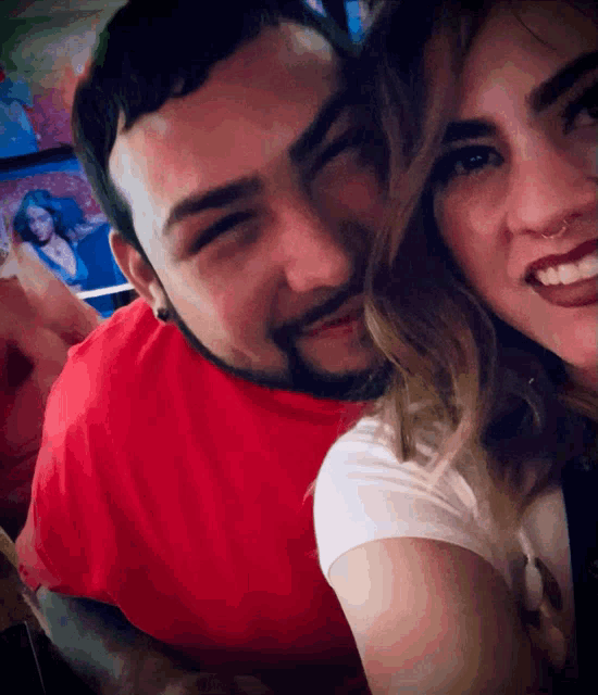 a man and woman are posing for a picture and the woman has a nose ring