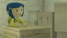 coraline from coraline the animated movie is sitting on a wooden table .