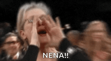 a woman is screaming in a crowd of people while holding her hands to her face .