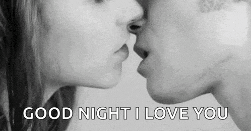 a man and woman are kissing in a black and white photo .