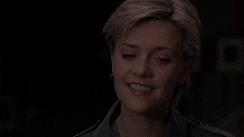a close up of a woman smiling with her eyes closed and her mouth open .