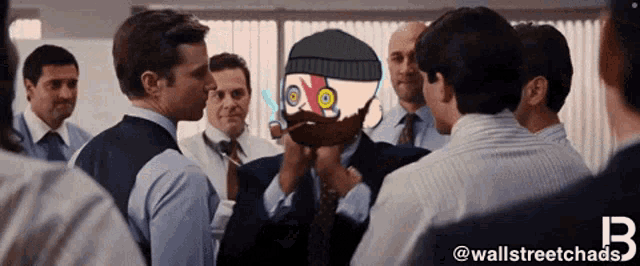 a group of men are gathered around a man with a cartoon face on his face