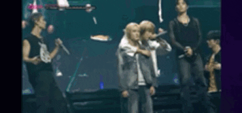 a group of people are standing on a stage with microphones in their hands .