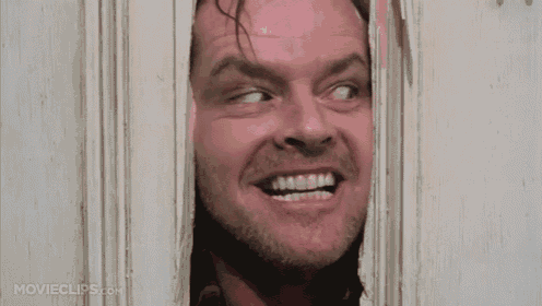 a man with his mouth open is looking through a hole in a door .