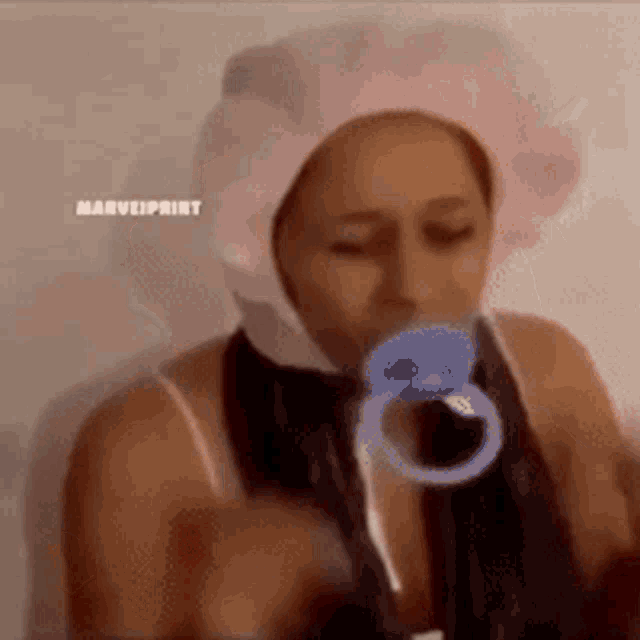 a woman wearing a pink shower cap and a pacifier in her mouth .