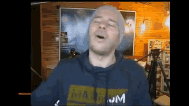 a man wearing a hoodie that says maximum is making a funny face