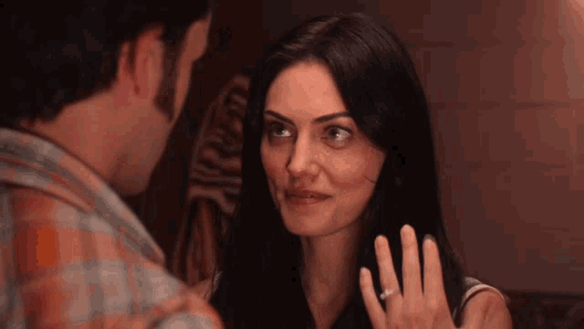 a woman with a diamond ring on her finger looks at a man