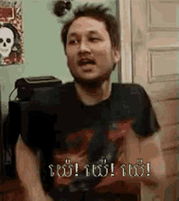 a man in a black shirt is standing in front of a door with his mouth open .