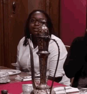 a woman is sitting at a table with a candle holder in front of her .