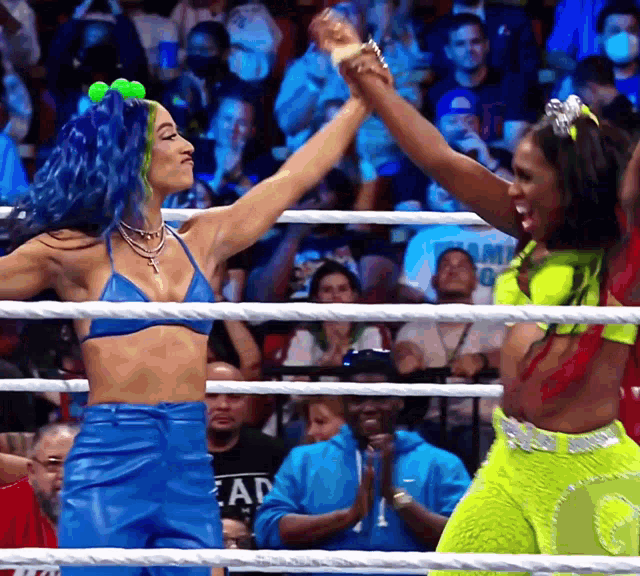 two women are giving each other a high five in a ring