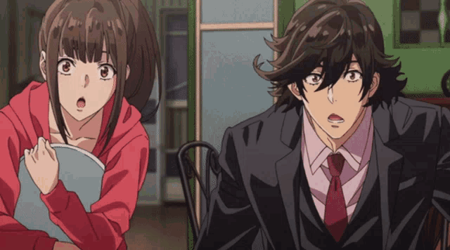 a man in a suit and tie stands next to a girl in a red sweater