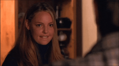 a woman in a black turtleneck is looking at a man in a room .