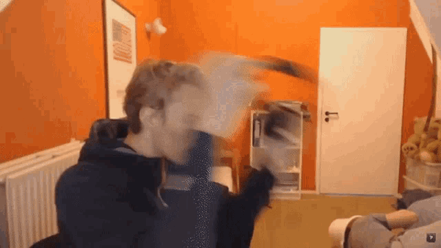 a man in a room with an orange wall and a white door