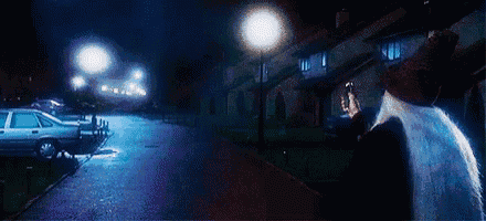 a man is standing on a street at night with a car parked in the background .