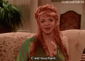 a woman with red hair is sitting on a couch and saying " c'est touchant " .