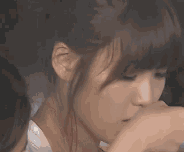 a woman covering her nose with her hand in a close up