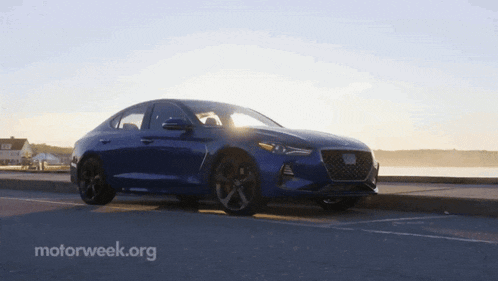 a blue car is parked on the side of the road with motorweek.org in the corner