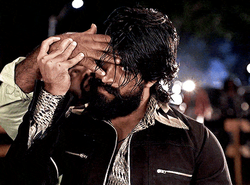 a man with a beard is holding his head with his hands