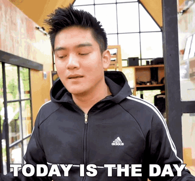 a man wearing a black adidas jacket says " today is the day "
