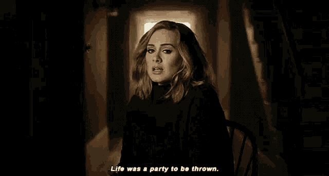 a woman is sitting in a chair in a dark hallway and says `` life was a party to be thrown . ''