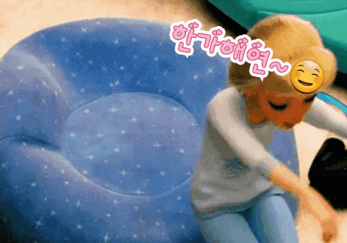 a cartoon character with a smiley face on her head is sitting on a blue inflatable chair