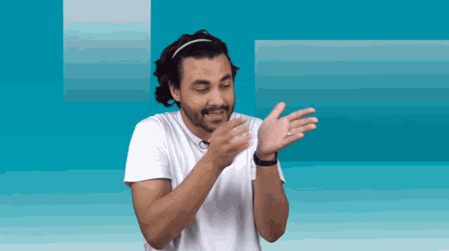 a man wearing a headband and a white shirt is clapping