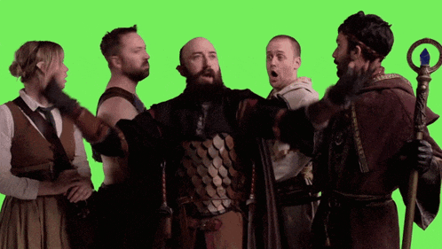 a group of people are standing in front of a green screen and one of them is holding a cane
