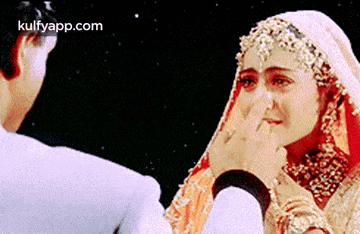 a man is putting his hand on a woman 's face while she is crying .