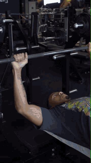 a man wearing a teenage mutant ninja turtles shirt is lifting weights in a gym