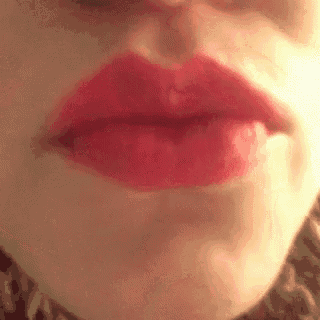 a close up of a woman 's lips with red lipstick on .