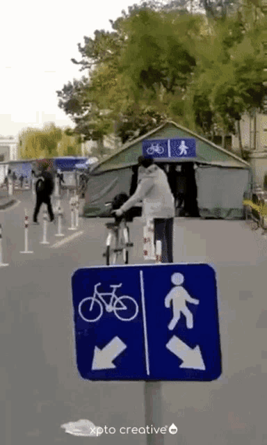 a man is riding a bike in front of a sign that says bicycle and pedestrian