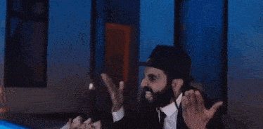 a man with a beard wearing a hat and a pin with the flag of israel on it
