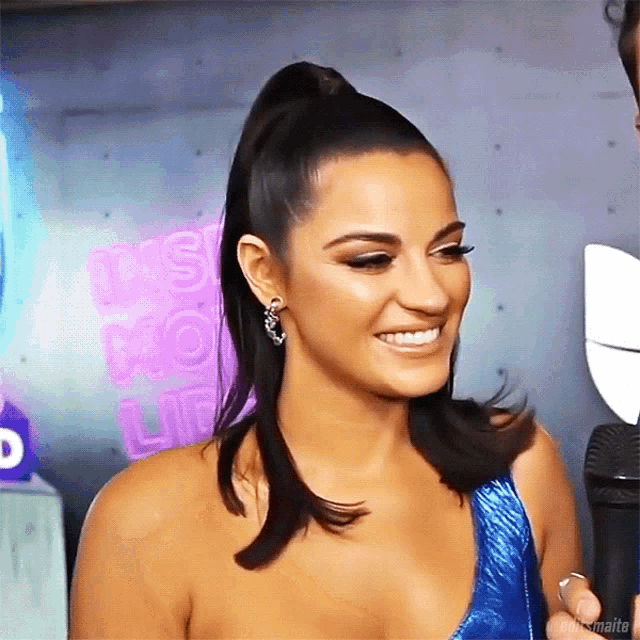 a woman with a ponytail is smiling in front of a sign that says it 's your life