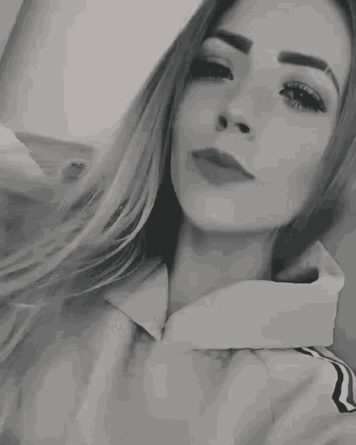 a black and white photo of a young woman with her tongue out