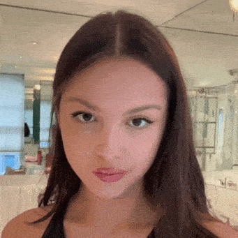 a close up of a woman 's face in front of a mirror in a bathroom