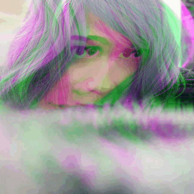 a woman with green and purple hair is looking at the camera