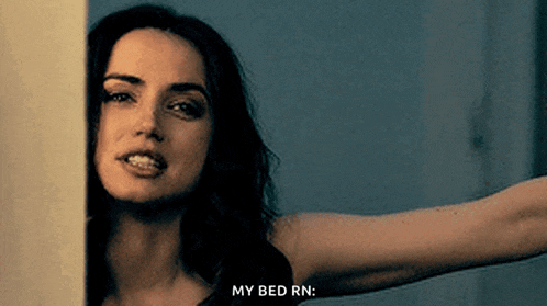 a woman is peeking out from behind a wall with her arm outstretched and says `` my bed rn '' .