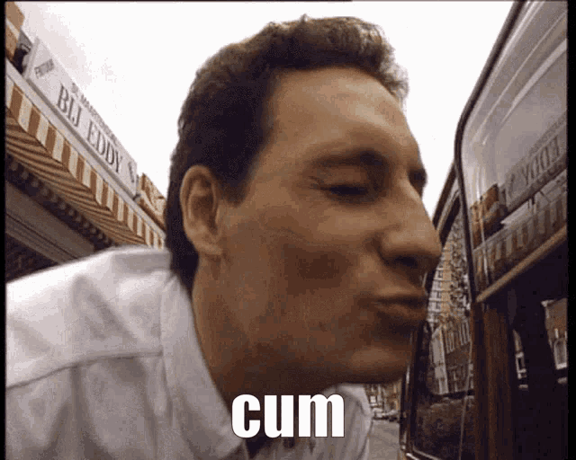 a man is blowing a kiss in front of a store that says bj eddy