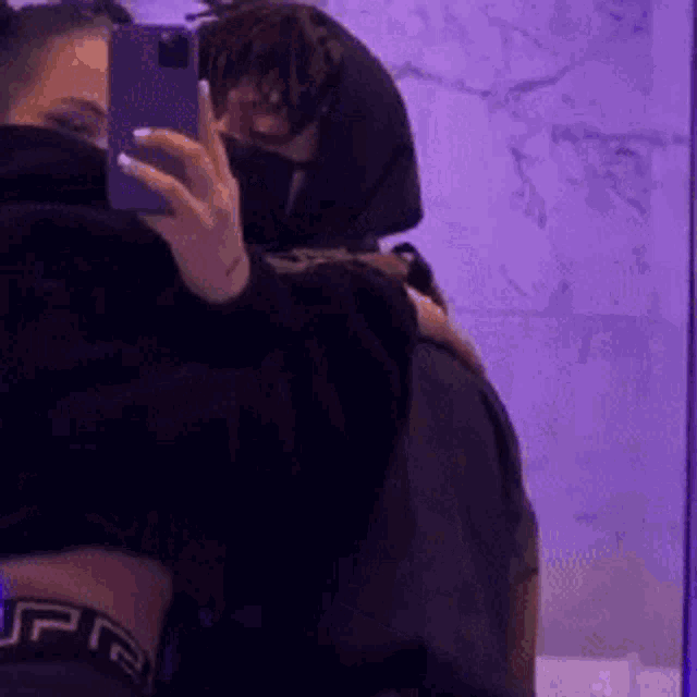 a person is taking a picture of themselves in a mirror with a cell phone .