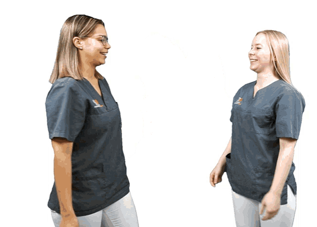 two women wearing scrubs with the word dental on the front are laughing
